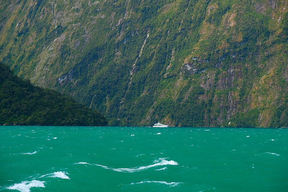 Mount Pembroke towers over a yacht in Milford Sound — Milford Sound, New Zealand