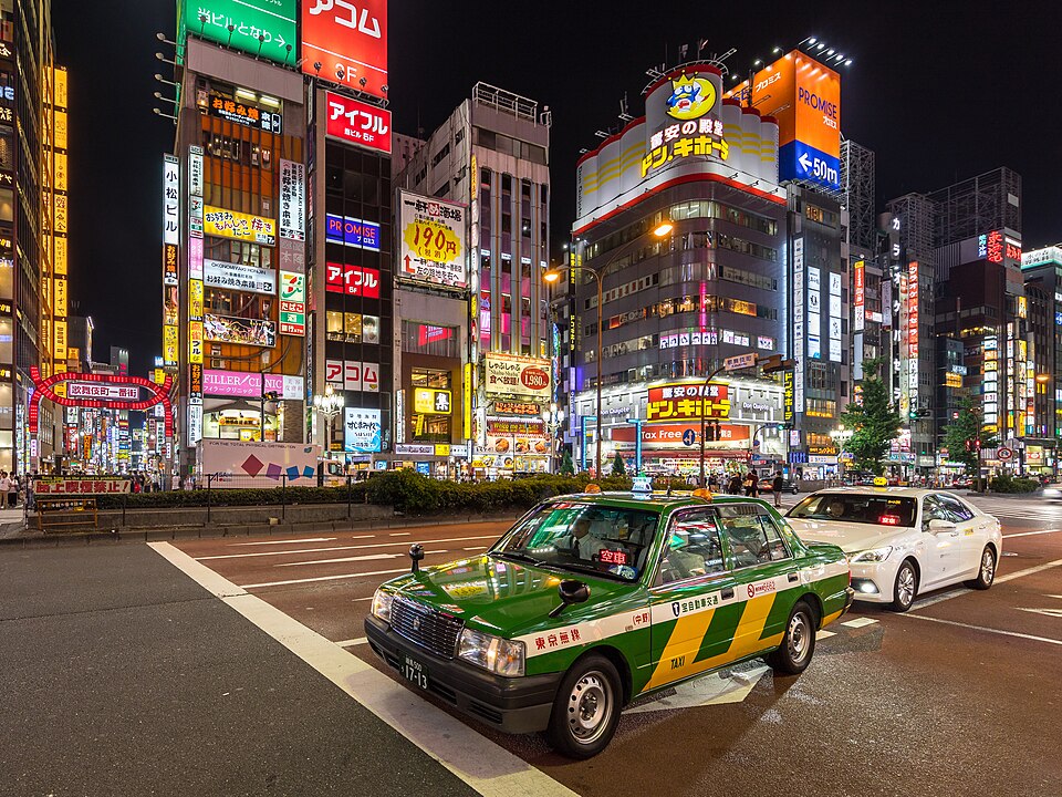 Green and yellow taxi at night in Yasukuni-dori Avenue, Shinjuku, Tokyo — Tokyo, Japan
