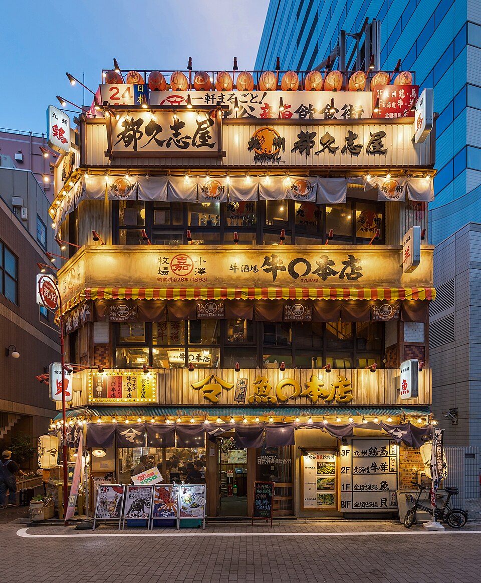 Illuminated facade of a 3-storey restaurant with Japanese signs and red paper lanterns, Ch — Tokyo, Japan