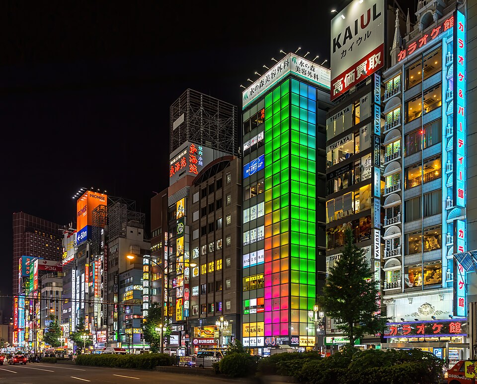 Colorful illuminated facades of buildings at night, with green, blue and pink lights, Kabu — Tokyo, Japan